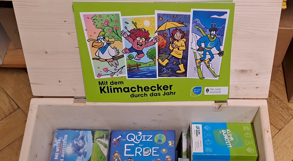 Geöffnete Klimakiste mit Büchern und Hörbüchern als Inhalt.