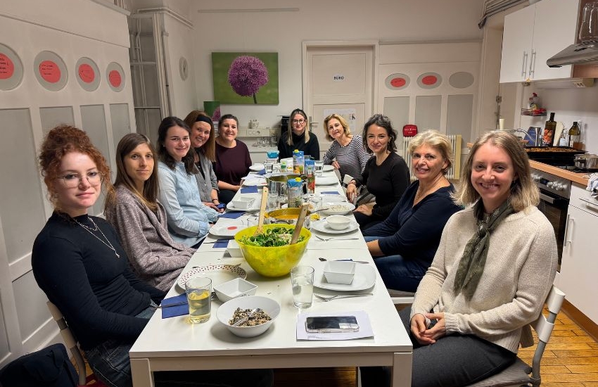 Gruppenbild, Menschen sitzen an gedecktem Tisch mit vielen guten Speise