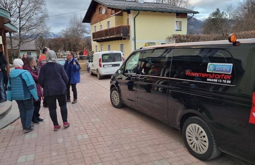 mehrere Menschen stehen draußen vor dem Gebäude und reden