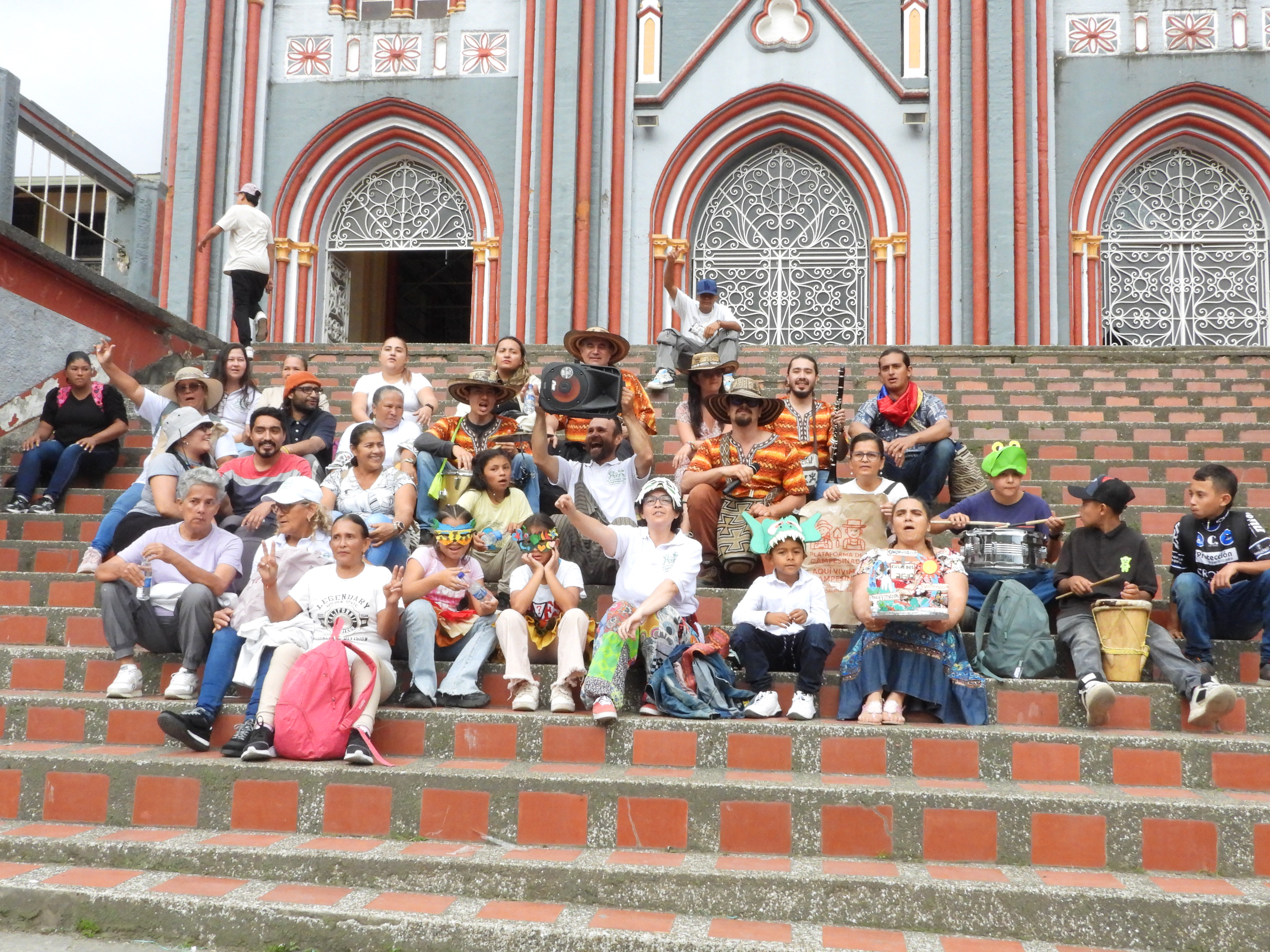 Wasser- und Bergfestival in Carmen de Atrato, mehrere Menschen sitzen auf Treppe vor Kirche zusammen