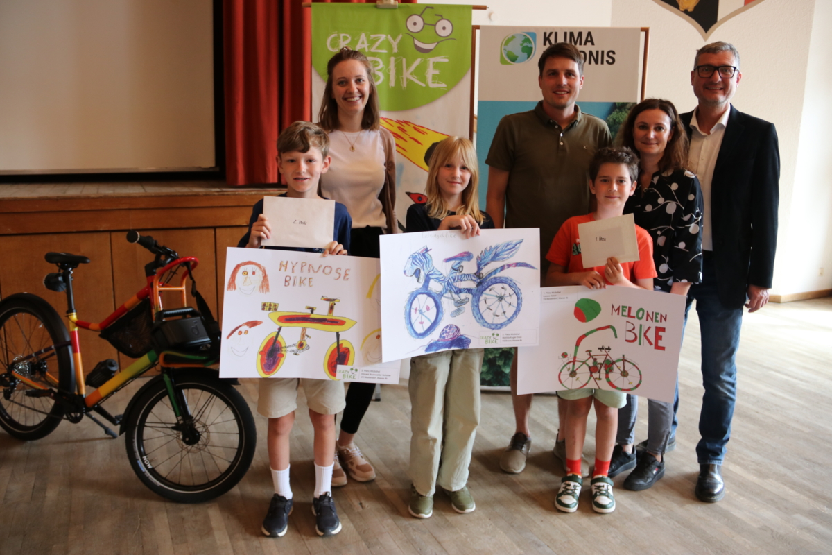 Drei Kinder zeigen ihre Zeichnungen von Fahrrädern